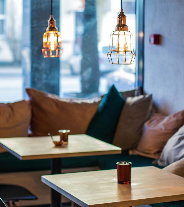 Warm and inviting cafe interior featuring modern pendant lighting and comfortable seating.
